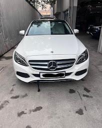 The front of a white Mercedes-Benz C-Class at the workshop