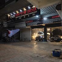 The Car Doctor India workshop lit up at night, seen from the road