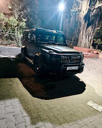 A black Mercedes-Benz G-Class parked at night